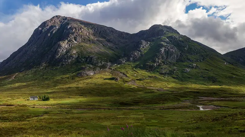 Buachaille Etive Mòr viewed from the A82 which runs through Glen Coe, with the white cottage of Lagangarbh next to the river Coupall. The cottage, converted…
